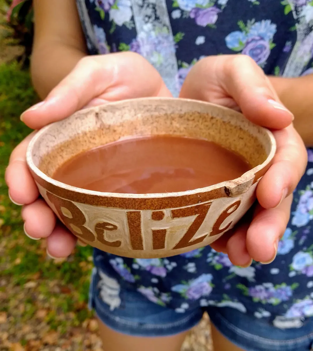 Hände halten eine Schale mit frischer belizeanischer Trinkschokolade