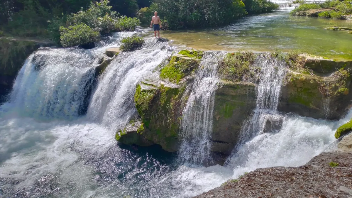 Breiter Wasserfall in einem Fluss im Regenwald von Belize